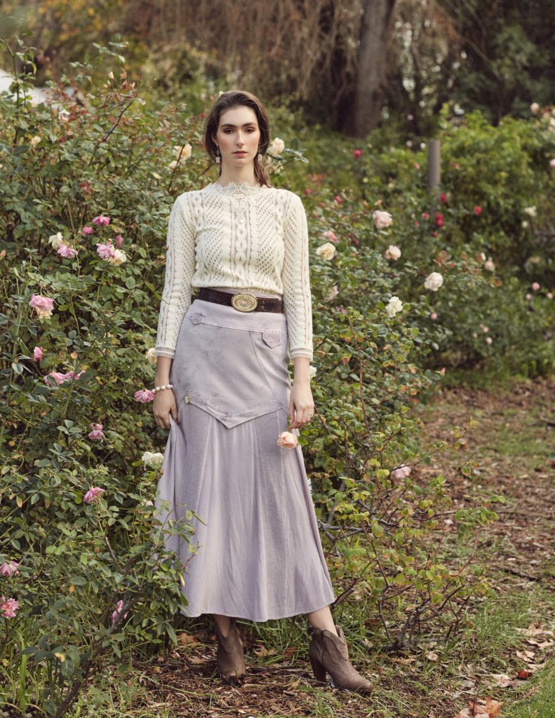 Woman in maxi-skirt standing in a garden with roses