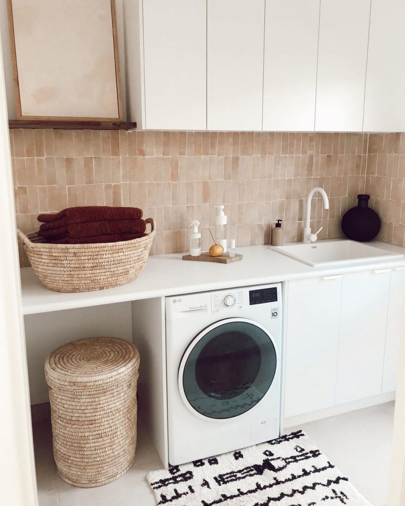 White laundry, showing washing machine, sink and wicker baskets