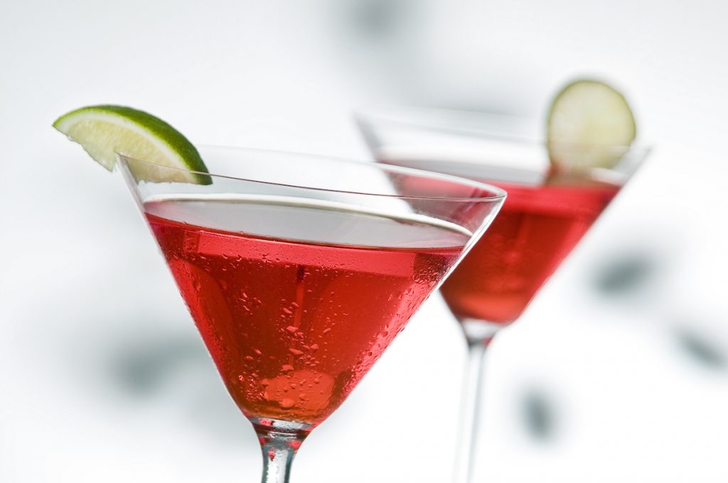 two red martinis with lime, focus is on front glass